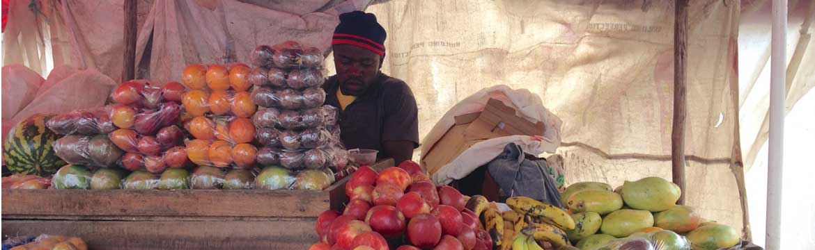 Man at market stall with fruit